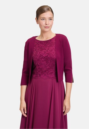 Bordeauxfarbenes Kleid mit Spitzenoberteil und Kardigan mit drei Viertelärmeln. Glatter Stoff, zarte Spitzenakzente und fließendes Rockdesign.