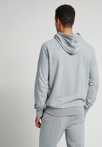 Grå, huva sweatshirt med raglanärmar. Slät textur, ribbat nederkant och ärmslut. Matchande byxor. Avslappnad sportig design.