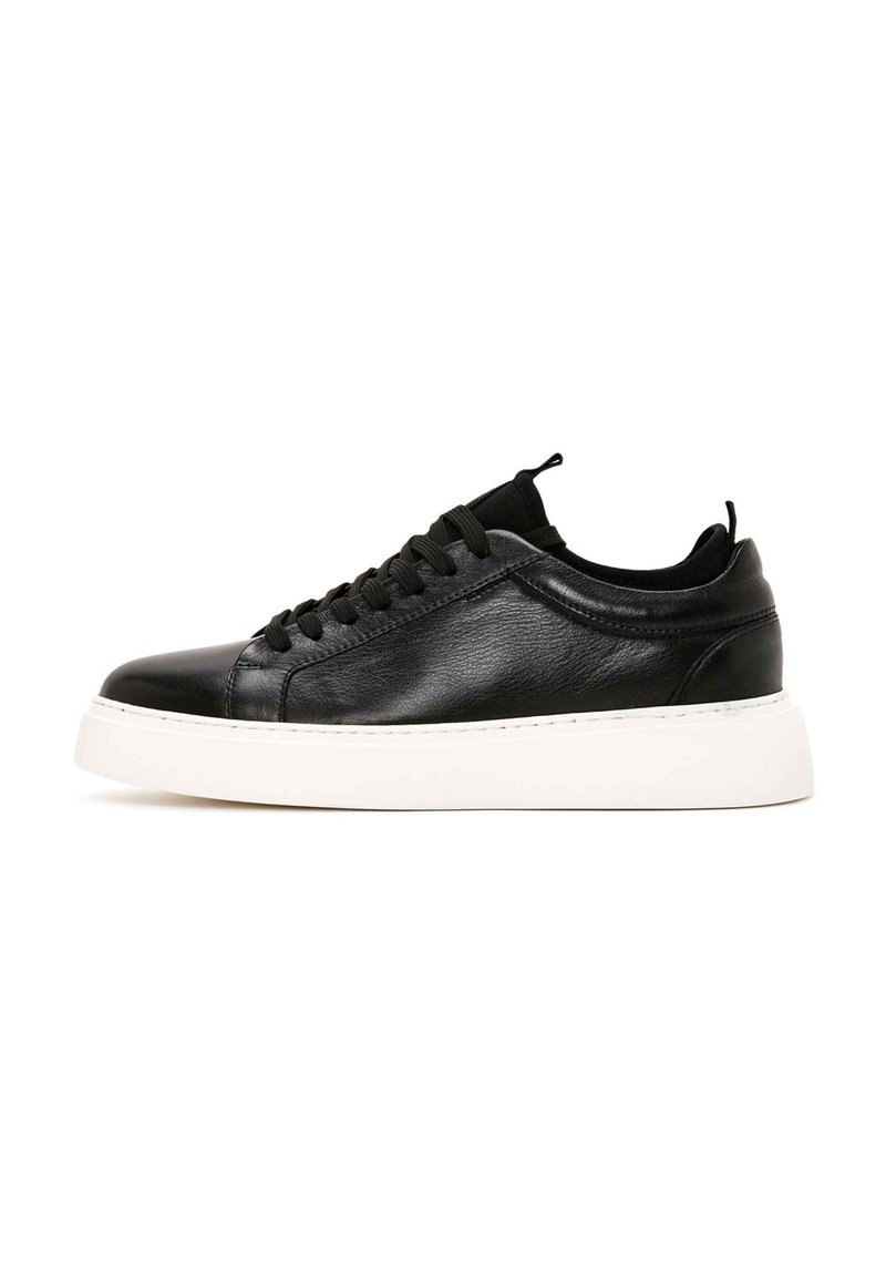 Sneaker nera in pelle con punta rotonda, design con lacci e suola in gomma bianca. Texture liscia con dettagli minimi e linguetta sul tallone.