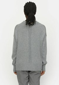 Grau übergroßer Pullover aus weichem Strickmaterial. Verfügt über einen hohen Kragen, Raglanärmel und gerippte Bündchen und Saum. Schlichte Gestaltung, keine Muster.