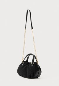 Black textured handbag with short leather handles, long gold chain strap with leather shoulder pad, and rounded base on white background.