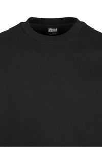 Sweat-shirt noir à col rond côtelé avec étiquette "Urban Classics" à l'intérieur du col, taille M, fabriqué en Chine.