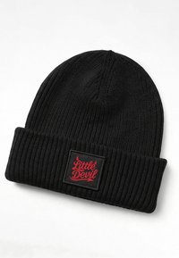 Black knit beanie with a ribbed texture. Features a folded cuff and a square patch displaying "Little Devil" in red script on a black background.
