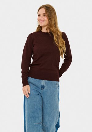 Burgundy knitted sweater with a round neck and long sleeves, paired with loose light blue denim pants. Soft texture, ribbed hem details.