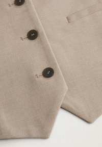 Gilet beige dalla texture liscia, caratterizzato da bottoni scuri, colletto a lancia e una tasca singola sul lato sinistro.