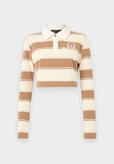 Πολύ κοντό πόλο με μακριά μανίκια σε μπεζ και κρεμ οριζόντιες ρίγες και λευκό γιακά, με μικρό κεντητό λογότυπο στο αριστερό στήθος.