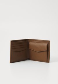 Hnedá kožená peňaženka otvorená, aby ukázala šesť priehradiek na karty a prednú kapsu. Hladký povrch s prešitými okrajmi a minimalistický dizajn.