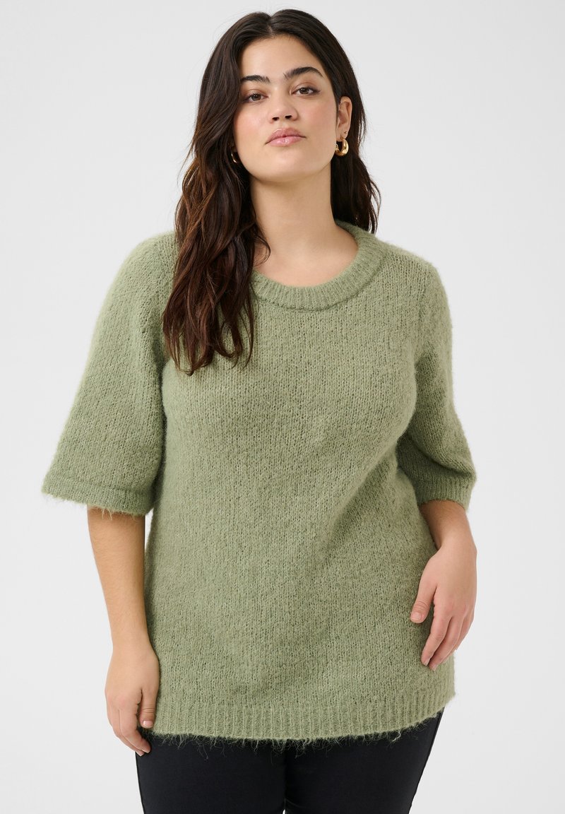 Green, fluffy sweater with a round neckline and short sleeves. Features a loose fit and slightly frayed hem at the bottom.