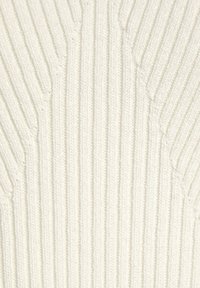 Pletený sveter v off-white farbe, s vertikálnou rebrovou textúrou s rôznou hĺbkou. Mäkká tkanina s jemnými tvarovacími detailmi.
