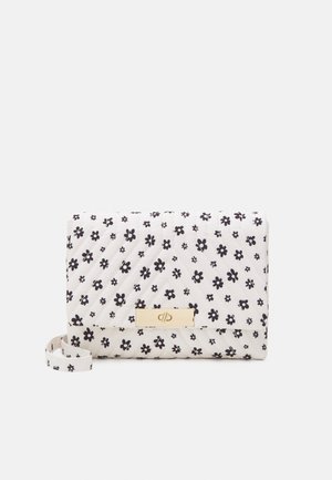 Petit sac à main blanc matelassé avec motif floral noir, fermoir doré et bandoulière en tissu assorti sur fond uni.