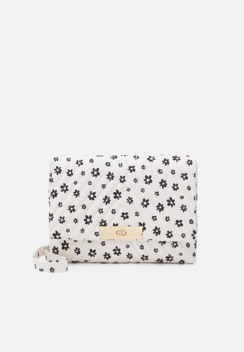 Petit sac à main blanc matelassé avec motif floral noir, fermoir doré et bandoulière en tissu assorti sur fond uni.
