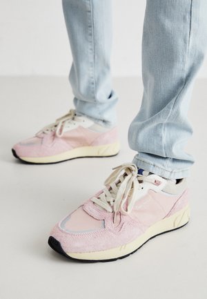 Rosa semsket og nettstoff sneakers med lysegrå detaljer, kremfargede snører og en gul mellomsåle, med en svart yttersåle og merkedetaljer.