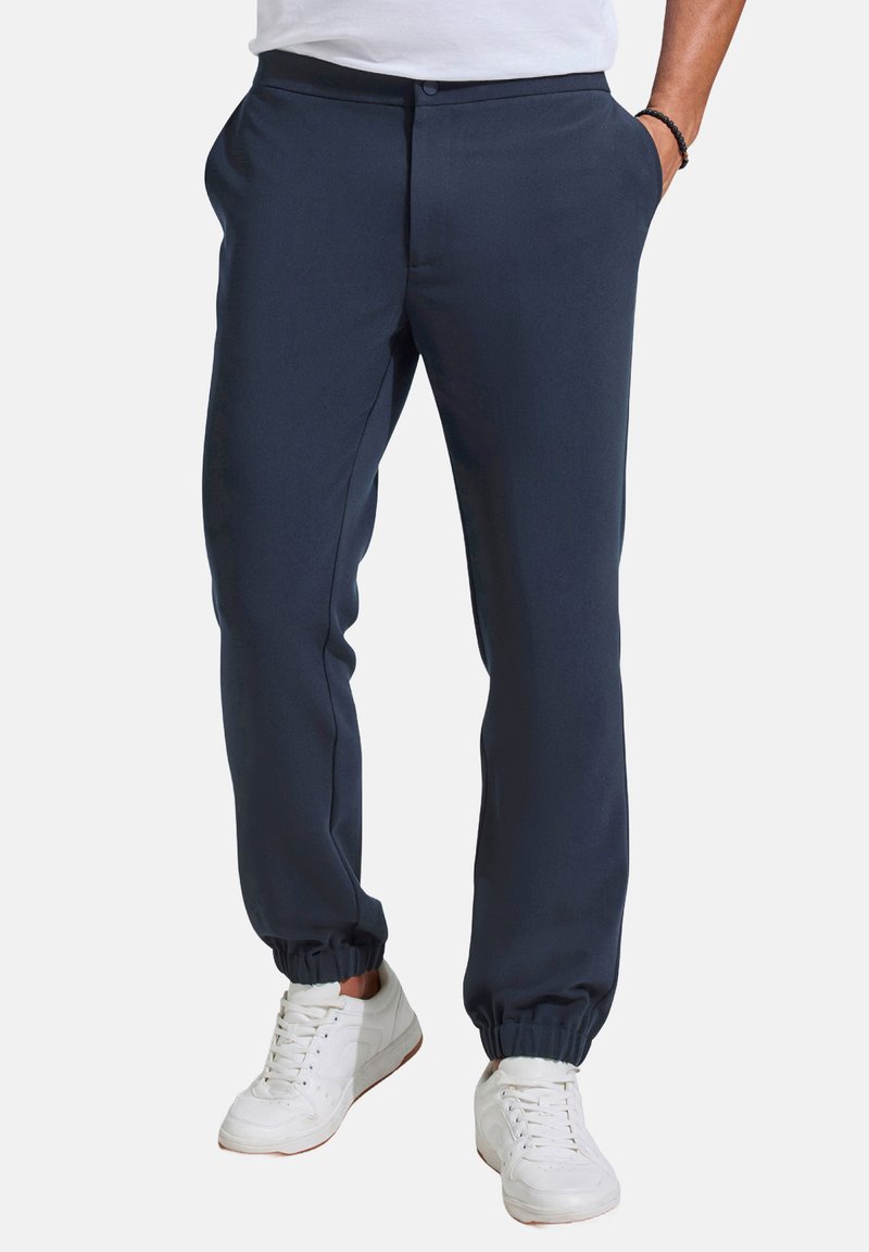 Marineblaue Jogginghosen aus einem glatten Stoff mit elastischem Bund und Bündchen; mit seitlichen Taschen und einem Knopfverschluss.