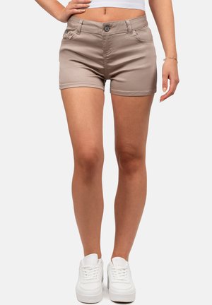 Shorts en denim marron clair avec un design ajusté, cinq poches et une fermeture à bouton. Portés avec des sneakers blanches sur un fond uni.