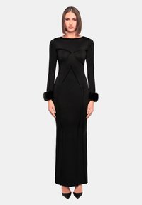 Schwarzes, langärmliges Kleid mit enganliegender Silhouette, versehen mit Kunstfellmanschetten und skulpturalen Nähten für ein strukturiertes Design.