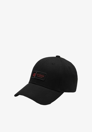 Mustapohjainen baseball-lakki, joka on valmistettu kankaasta ja jossa on muotoiltu kupu. Edessä on suorakulmainen musta merkki, jossa on punaiset "ombre"-teksti ja logo.