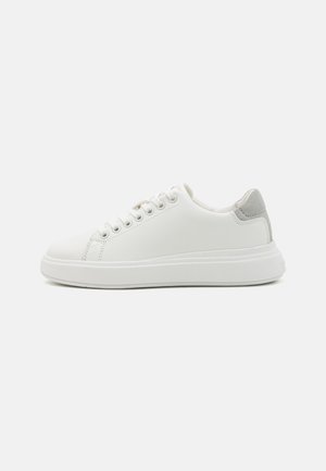 Bela športna sneakers čevlja iz gladkega sintetičnega materiala z sivo semiš usnjem na peti, z okroglo konico in ravnim gumijastim podplatom.
