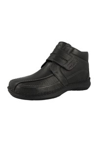 Botín negro de cuero hasta el tobillo con una punta redondeada, doble cinta de Velcro, costuras en contraste y una suela de goma para agarre y flexibilidad.