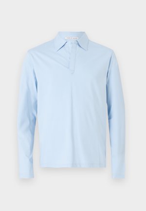 Lyseblå langermet polo skjorte laget av myk bomull. Har klassisk krage og en knappestolpe med en subtil sømdetalj foran.