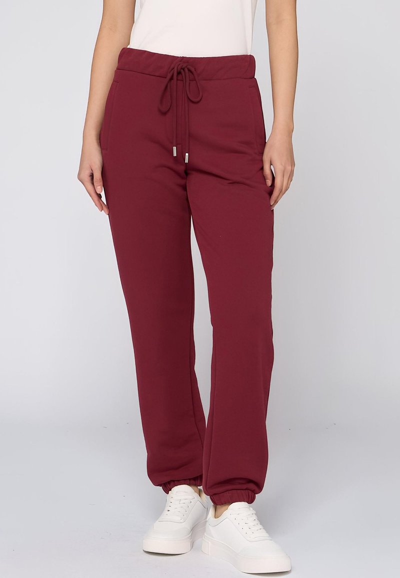 Bordeauxrode sweatpants met een elastische tailleband en trekkoord. Bevat zijzakken en elastische boorden, gemaakt van een zachte katoenmix.