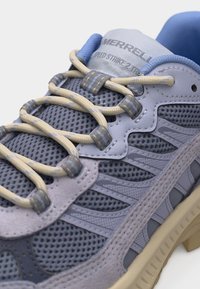 Πεζοπορικό παπούτσι Merrell Speed Strike σε μπλε και γκρι με μπεζ κορδόνια, διχτυωτό επάνω μέρος και ραμμένες συνθετικές επικαλύψεις, κοντινή λήψη στην περιοχή των κορδονιών.
