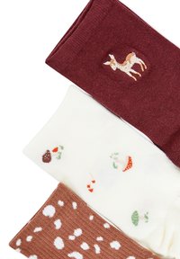 Tre paia di calzini che mostrano un calzino bordeaux con un ricamo di cervo, un calzino bianco con motivi di frutta colorata e un calzino marrone con macchie bianche.