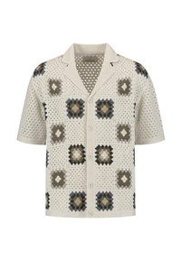 Korte mouw blouse met een crèmekleurig haakpatroon met vierkante patronen in donkerbruin, grijs en tan. Heeft een kraag en een knoopsluiting.