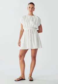 Weißes, kurzärmeliges Kleid mit elastischem Bund, Zugdetail und lässiger Silhouette. Glatter Stoff mit einer leichten, luftigen Textur.