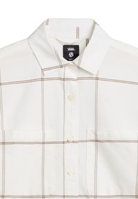 Camicetta bianca a maniche corte con motivo a quadri marrone, colletto button-down, due tasche sul petto e una piccola etichetta con logo vicino al colletto.