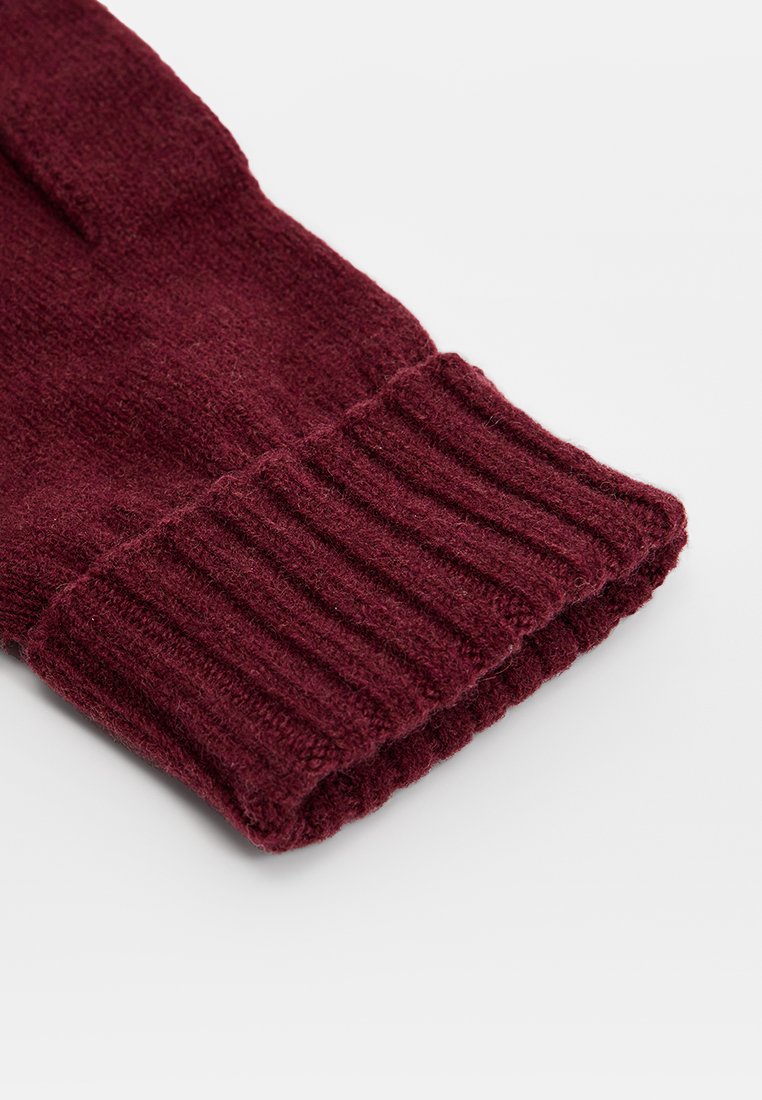 Bordeaux gebreide handschoenen met een geribbelde manchet; zachte textuur en naadloze constructie, geschikt voor koud weer.
