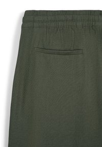 Pantaloni verde scuro in tessuto a trama con vita elasticizzata e una sola tasca posteriore, caratterizzati da un design e una texture semplici.