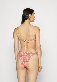 Bikini set in a multicolored floral print with thin straps, a tie-back detail, and a low-rise bottom. Made from a smooth fabric.