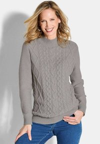Grau gestrickter Pullover mit strukturiertem Zopfmuster, gerippten Bündchen und Saum. Kombiniert mit blauen Jeans, lässig getragen.