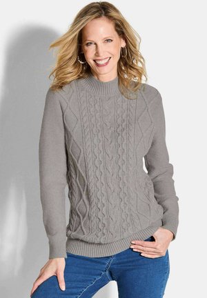 Grau gestrickter Pullover mit strukturiertem Zopfmuster, gerippten Bündchen und Saum. Kombiniert mit blauen Jeans, lässig getragen.