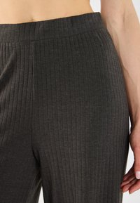 Dunkelgraue Ripp-Shorts mit einem breiten elastischen Bund, die vertikale Linien und eine weiche Textur aufweisen. Keine sichtbaren Taschen.