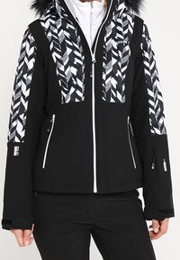 Czarna kurtka narciarska z białymi geometrycznymi wzorami na ramionach i kapturze, wykończona sztucznym futrem. Kieszenie na zamek i białe akcenty.