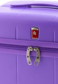 Maleta rígida morada con una superficie texturizada, que cuenta con un doble zip y un acento del logotipo en hardware plateado.