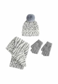 Mössa med grå tofs, vit bas med grå djurtryck, matchande halsduk med liknande mönster och gråa handledsvärmare utan fingrar, allt i mjuk textur.