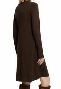 Vestito a maglia marrone con maniche lunghe, scollatura rotonda e lunghezza midi. Presenta un polsino e un orlo a costine per aggiungere texture e dettagli.