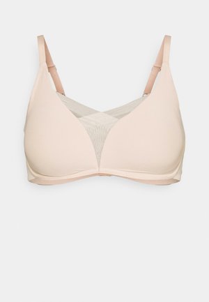 Sutiã bege suave com um tecido liso e elástico. Apresenta um inserto de malha com um padrão subtil, alças ajustáveis e um design sem costuras.