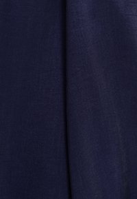 Niebieski spleciony materiał o gładkiej teksturze, złożony, aby pokazać głębię. Posiada subtelny połysk i drobną teksturę.