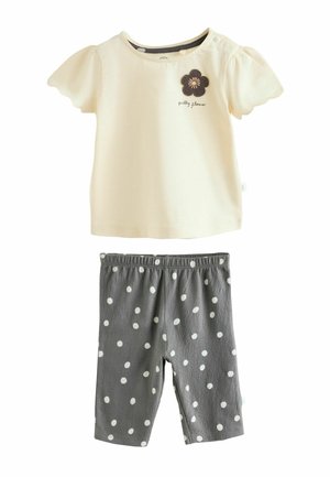 Cream short-sleeve baby shirt with scalloped edges and "pretty flower" text paired with gray leggings featuring white polka dots.