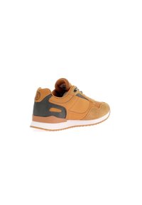 Zapatilla marrón con parte superior de ante y cuero sintético, que cuenta con una suela acolchada, punta redondeada y acentos oscuros en contraste.