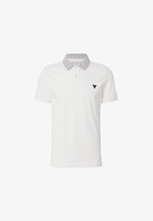 Camisa polo blanca con un cuello azul marino estampado, que cuenta con dos botones y un pequeño logo triangular en azul marino en el pecho. Textura de tela suave.