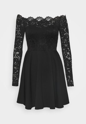 Czarna sukienka odsłaniająca ramiona z długimi koronkowymi rękawami i koronkowym gorsetem, z gładkim, rozkloszowanym dołem.