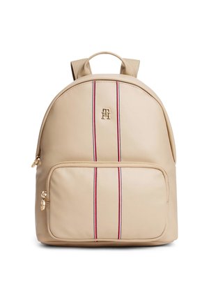 Sac à dos beige avec deux bandes verticales rouges et noires, poche avant zippée, poignée supérieure, bretelles rembourrées et emblème logo ton or.