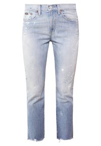 Světle modré denimové džíny se rovnými nohavicemi, opotřebovanými detaily, třepeným lemem a jemnými akcenty barvy na cárech.