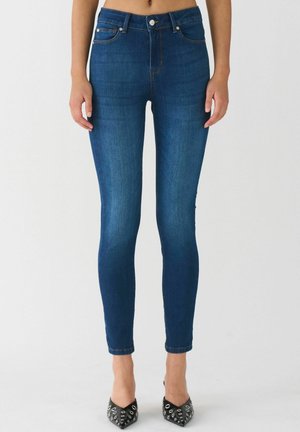 Skinny blue jeans made of denim, featuring a high waist, five-pocket design, contrasting stitching, and a sleek fit down to the ankles.