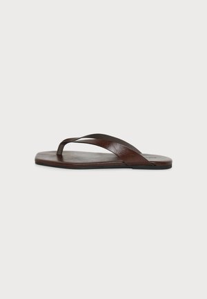 Sandale tongs en cuir marron avec une bride simple et une semelle plate vue de côté sur fond blanc.