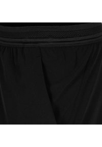 Pantalones cortos deportivos negros con una suave cinturilla elástica y un detalle de malla transpirable. Presentan una textura suave y un corte holgado para mayor comodidad.